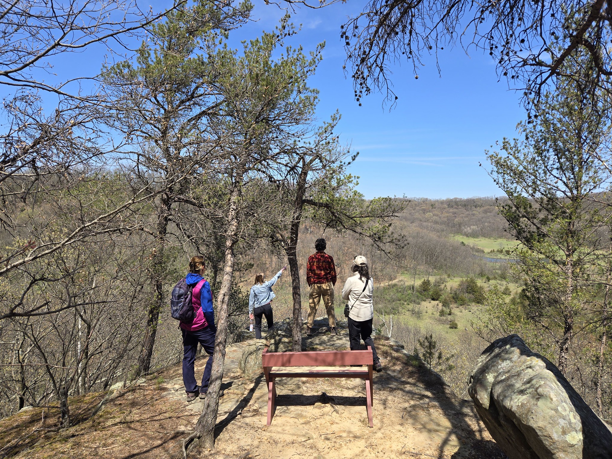 Group standing on a rock ledge looking towards rolling land